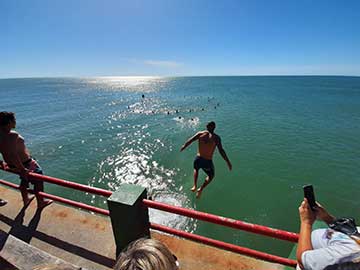 Hombre al agua! el tradicional salto desde el Muelle, con poca concurrencia de guardavidas